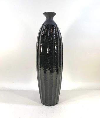 a black vase sitting on top of a white table