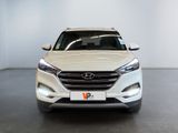 the front view of a white suv parked in a showroom