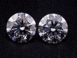 une paire de diamants taille ronde sur un fond noir