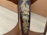 a close up of a wooden table with a metal decoration on it
