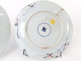 pair of blue and white plates with designs on them on a white surface