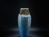 un vase bleu posé sur une surface noire