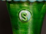 a green vase with a green and white number 2 on it