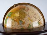 a small globe on a wooden stand with a white background