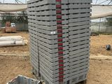 une pile de briques posée sur une palette, dans la terre
