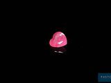 a pink heart shaped diamond on a black surface