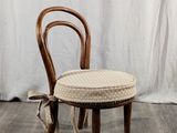 une image représentant une chaise en bois sur laquelle est posé un coussin