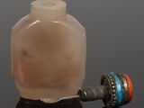 a small glass bottle with a handle on a black surface