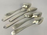six silver spoons are lined up in a row on a white surface
