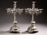 pair of silver plated candelabs with candles on stands