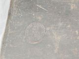 a silver plate with a coin on it sitting on a table