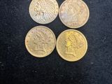 four different types of coins on a black surface