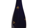 un vase bleu orné de fleurs dorées sur fond blanc