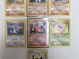 several pokemon cards are on a white surface with a white background