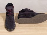 pair of men ' s shoes on a wooden table with a white wall in the background
