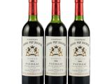 three bottles of red wine sitting next to each other on a white surface