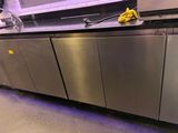 un plan de travail en acier inoxydable sur lequel repose une éponge jaune