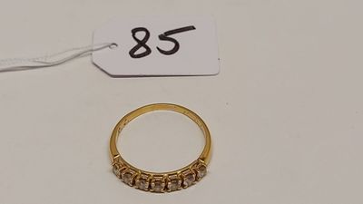 une bague en or et une étiquette posées sur une table blanche