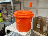 a large orange bucket sitting on a shelf in a kitchen