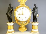 a clock with a statue of a man and a woman on top of it
