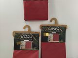 three bags of red fabric hanging on a wall in a room