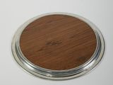 a close up of a wooden and metal coaster on a white surface