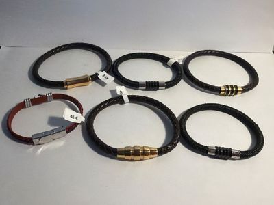 six different bracelets with tags on them sitting on top of a table