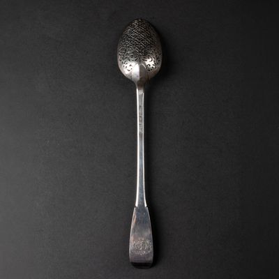 silver spoon on a black background with a textured surface