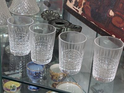 bottles and glasses on a glass shelf in a glass case