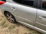 a silver car with a red stripe parked on the side of the road