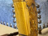 a close up of a wooden chair with metal studding