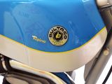 a blue and white motorcycle with a yellow emblem on it