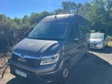 La camionnette est garée sur le bord de la route, à côté d'une voiture.