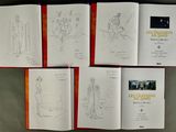 six books with drawings of people on them sitting on a table