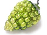 green glass ornament shaped like a bunch of grapes on a white background
