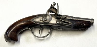 un vieux pistolet avec une poignée en bois sur une surface blanche