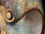 a close up of a decorative mask with a metal handle