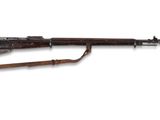 un fusil avec un canon en bois et une bretelle en bois sur fond blanc