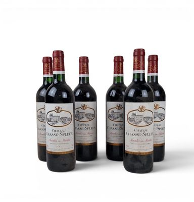 three bottles of red wine sitting next to each other on a white surface