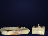 pair of carved soap dishes on a dark blue background