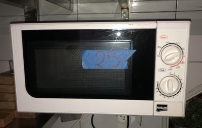 un micro-ondes blanc avec un autocollant bleu dessus