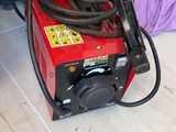 a person laying on the floor next to a red and black machine