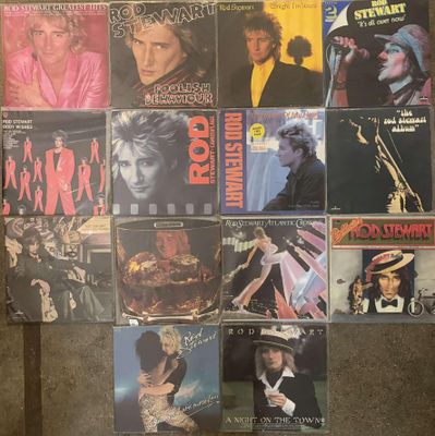 many different album covers on the wall of a room