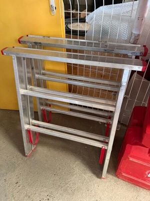 une étagère métallique posée à côté d'une chaise rouge