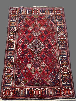 un ancien tapis persan à motifs rouges et bleus