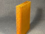 un vieux livre jaune posé sur une surface grise