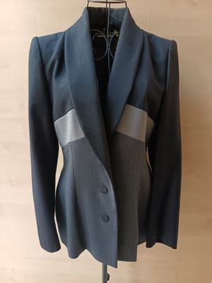 grey jacket on a mannequin stand on a wooden floor