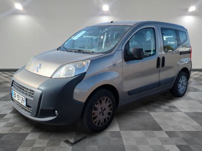 la petite camionnette argentée est garée sur un carrelage à carreaux
