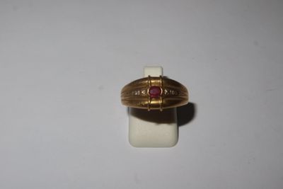 a gold ring with a red stone in it