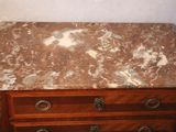 a marble top chest of drawers in the corner of a room